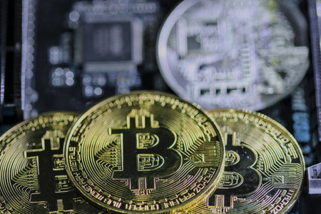 Bitcoin coins are stacked on a computer device. The idea of digital coin prices goes down, shut down and stop mining.の写真素材