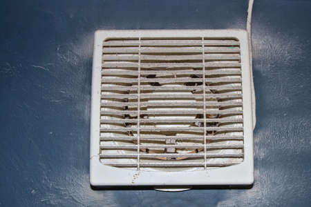 The exhaust fan in the bathroom is unclean, dirty, leaving a lot of dust and powder on the blades and safety masks.の写真素材
