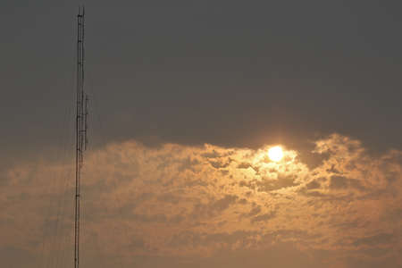The golden yellow sky in the evening with a strong transmission tower. Concepts of natural phenomena that we cannot defineの写真素材