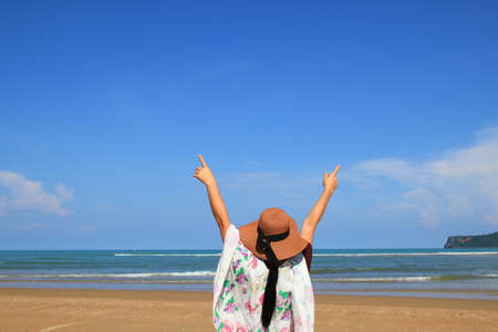The girl wears a wide-brimmed hat and a white floral shawl. Raise both hands happily while admiring...