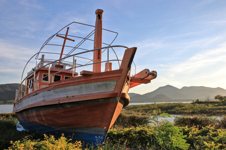 Old fishing boat on the shore of a lake in the morning.の写真素材