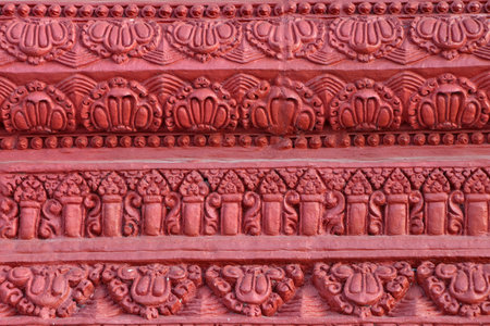 Carved patterns on the concrete walls of the Ashram are painted red.の写真素材