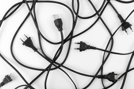 Messy of electrical cords plug and wires unconnected top view on white background, messy electric equipment flat lay concept.の写真素材