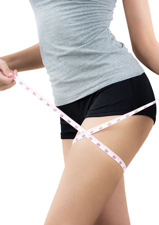 asian woman measuring her thigh and showing perfect body, Isolated on a white background.の写真素材
