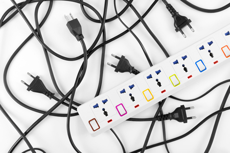 Messy of electrical cords plugs and wires unconnected electrical power strip or extension block  with messy wires, top view on white background, messy electric equipment flat lay concept.の写真素材