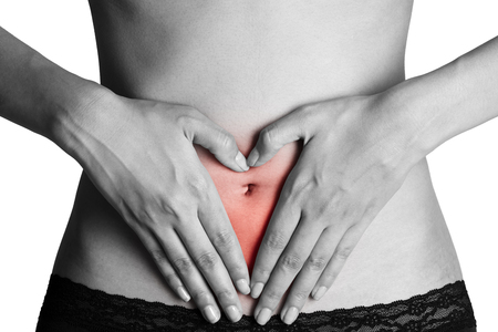 Woman holding her stomach with red highlighted on pain area, black and white color isolate on white background.の写真素材