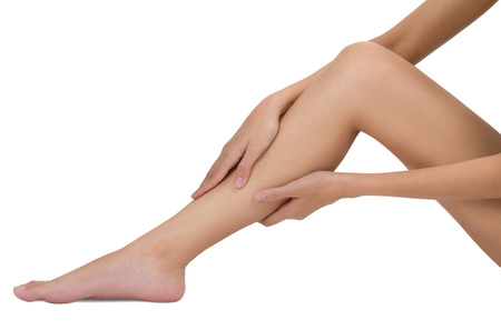 woman holding her beautiful healthy long leg with massaging shin and calf in pain area, Isolated on white background.の写真素材