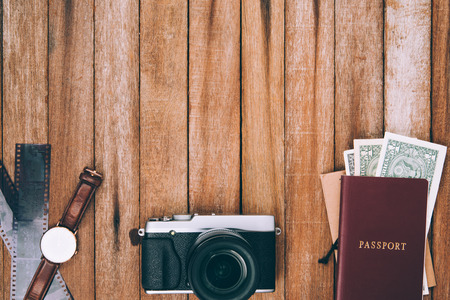 Preparation for travel,  money, passport, camera, in vintage color on wooden table with copy space.の写真素材