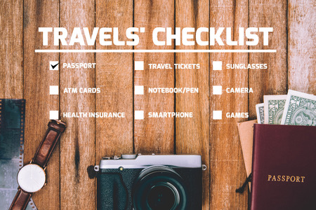 Travel Checklist for Preparing for a Trip, mobile phone, money, passport, camera, pencil ,eyeglass, book, Watch, in vintage color on wooden table Checklist.の写真素材