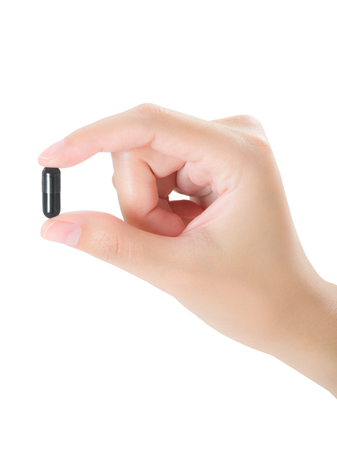 woman beautiful healthy hand holding medicine color black capsule, assistance concept, isolated on white backgroundの写真素材