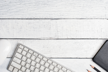 Creative vintage workspace table with key board, pencil, note book, mouse, top view with Copy Space, on vintage white background.の写真素材