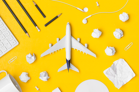 Travel Planning. Airplane, pencil, paper note, paper cilp, earphone, calculator with blank space. Preparation for Traveling and Flat lay Concept.の写真素材