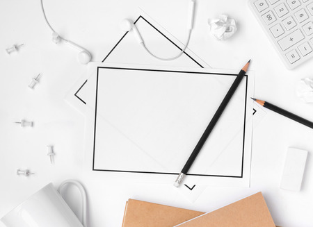 Office table desk with blank paper sheet, pencil, push pin, calculator, earphone, paper note on white background. business and office supplies flat lay concept.の写真素材