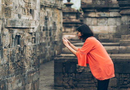 Asian female solo travelers use smartphone take photo ancient buildings- Borobudur temple- Java -Indonesia- Asia.の写真素材