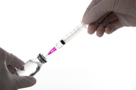 Doctor or scientist hands wear rubber gloves holding and using syringe to suck liquid vaccines from medicine vials in the laboratory- Health Beauty and medical concepts- Isolated on white backgroundの写真素材