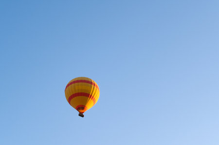 Colorful hot air balloons fly over the blue sky at sunrise with copy spaceの写真素材