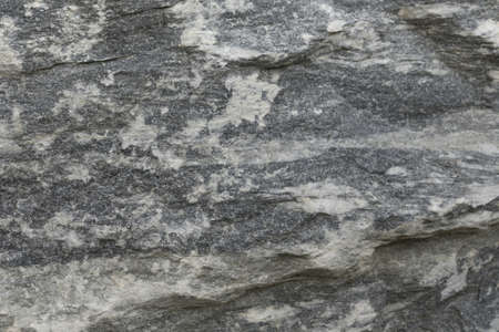 Split gray-white rock. Close-up of granite stone as background.