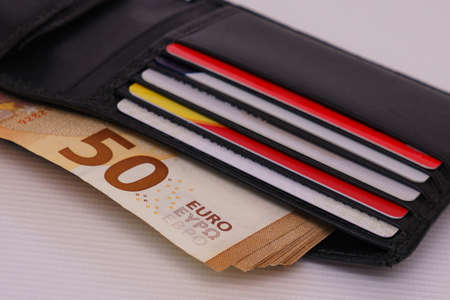 Open leather wallet with cards and fifty euro bills. Close up.
