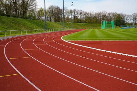 Sport stadium with running tracks strip. Green lawn.