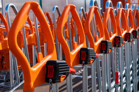 Shopping trolleys with orange handles lined up at hardware store. close upの写真素材