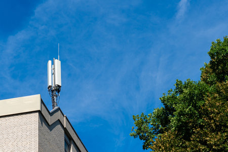 Broadcasting antenna on the roof of the administrative building. Blue sky with light white clouds...