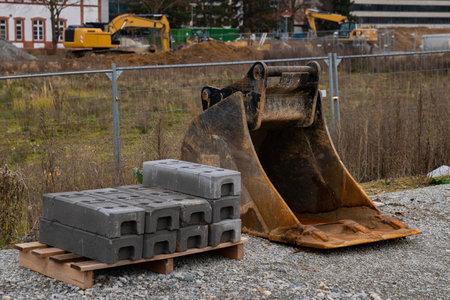 Concrete blocks and bulldozer bucket at construction site. Close up.の写真素材