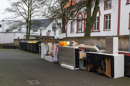Old damaged furniture on street outside house for transportation to a landfill. Garbage containers...