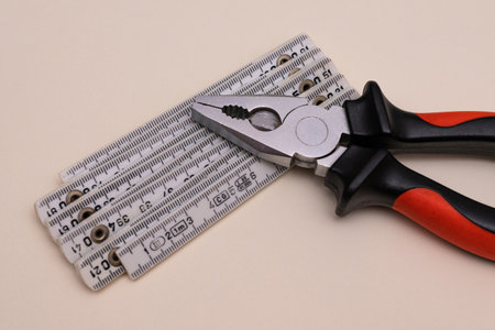 Pliers and a folding ruler lying on a light background. close upの写真素材