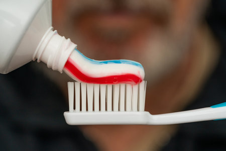 Squeezing colored toothpaste onto a toothbrush. Close up.の写真素材
