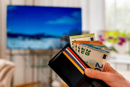 Hand of a man holding a wallet with monetary european banknotes and plastic cards. Closeup.の写真素材