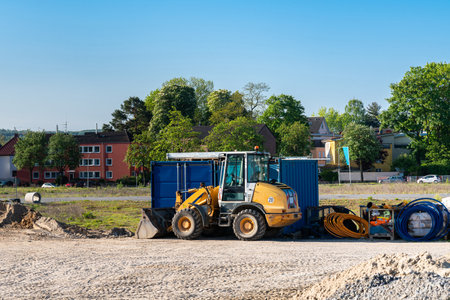 Construction site with a yellow wheeled bulldozer standing on it and folded cables.の写真素材