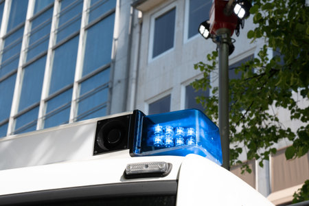 Blue flashing light and loudspeaker on the roof of a white rescue track. Closeup.の写真素材