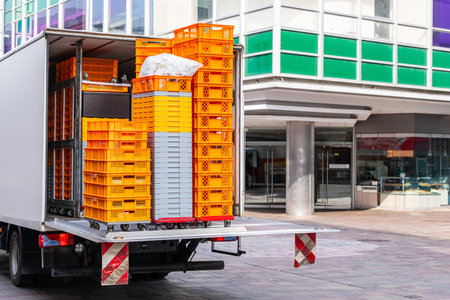 A car with plastic orange and white boxes for goods stands on the pedestrian zone of the city.の写真素材