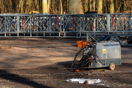 A generator sits on a clearing in a forest. Metal scaffold structures are arranged in the...