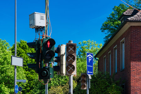 Bright green traffic lights illuminate the street while a red light signals vehicles to stop....