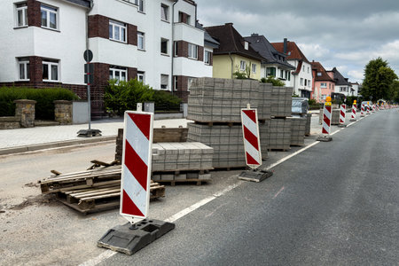 Concrete paving slabs stacked on wooden pallets. Roadwork on a city street.
