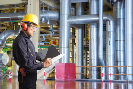 Engineer taking notes for maintenance work  in thermal power plant factoryの写真素材