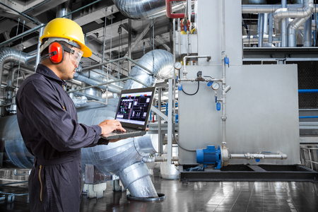 Engineer using laptop computer in thermal power plant factoryの写真素材