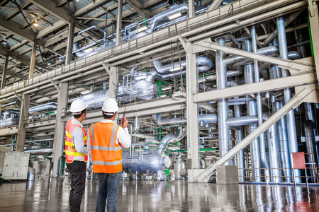 Engineer working in a thermal power plant with talking on the walkie-talkie for controlling workの写真素材