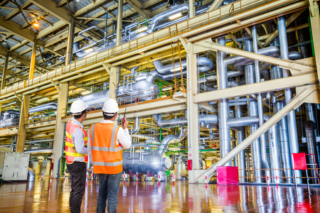 Engineer working in a thermal power plant with talking on the walkie-talkie for controlling workの写真素材