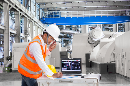 Engineer using laptop computer for maintenance equipment in thermal power plant factoryの写真素材