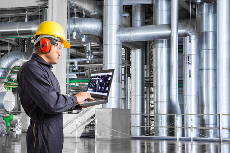 Engineer using laptop computer for maintenance equipment in thermal power plant factoryの写真素材