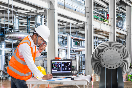 Engineer using laptop computer in thermal power plant factoryの写真素材