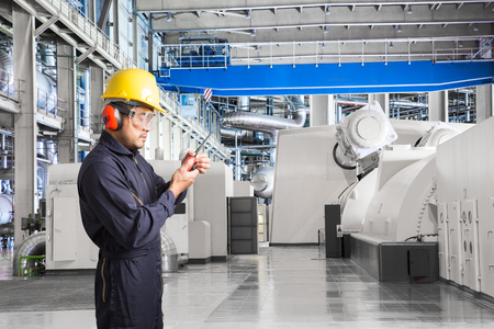 Engineer working in a thermal power plant with talking on the walkie-talkie for controlling workの写真素材