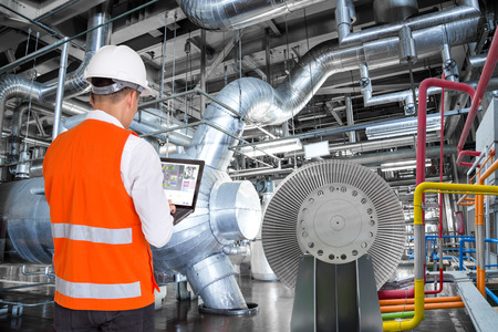 Engineer using laptop computer for maintenance in thermal power plant factory