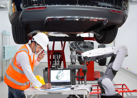 Mechanic with assistance robotic inspection wheel balancing of modern car in automotive industry 4.0 conceptの写真素材