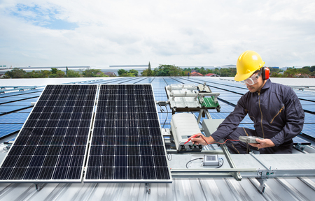 Engineer maintenance solar panel equipment on factory roofの写真素材