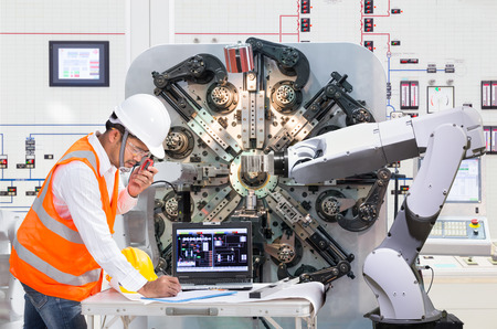 Engineer using laptop computer for maintenance automatic robotic hand machine tool at factory, Industry 4.0 conceptの写真素材