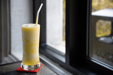 Glasses of pineapple juice on classic table with window lightの写真素材