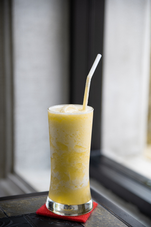 Glasses of pineapple juice on classic table with window lightの写真素材